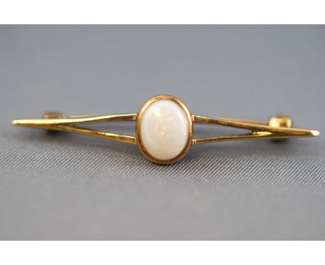 A collection of jewellery to include: A yellow metal bar brooch centrally set with an oval cabochon commercial quality opal. 