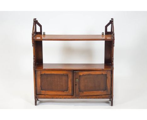 A Victorian mahogany hanging wall shelf, with two tiers above two panelled doors, with shaped and pierced sides, 67cm high x 