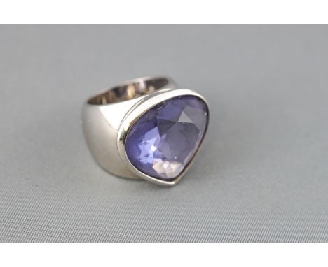 A Swarovski ring, set with a large drop shaped facet cut clear purple crystal and stamped with the Trade mark Swan