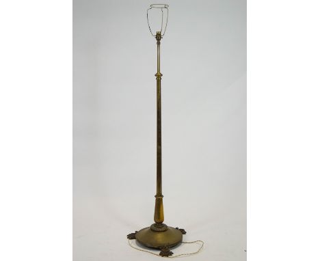 A brass telescopic standard lamp, on round base with three paw feet, 132cm high