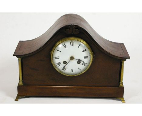 A 19th century mahogany cased mantel clock with arched top, brass columns and feet, white enamel dial and French movement str