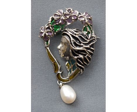 A white metal abstract brooch depicting female profile finished with enamel and a drop freshwater pearl.  Pin and revolver fi