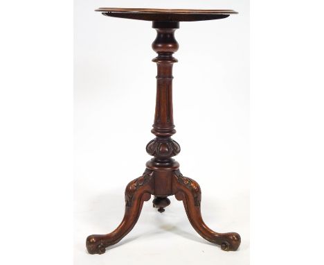 A Victorian mahogany tripod occasional table, the dish top on carved and fluted baluster pedestal on cabriole legs with leaf 