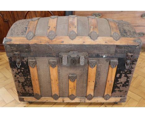 An Edwardian oak and embossed steel dome top cabin trunk, having an internal compartment to the lid, 87 x 47 x 63 cm
