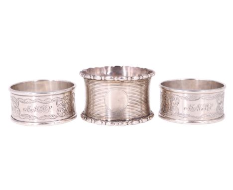 Three early 20th Century silver napkin rings, comprising a pair having floral engraving and bearing initials 'MMPJ', and a ca