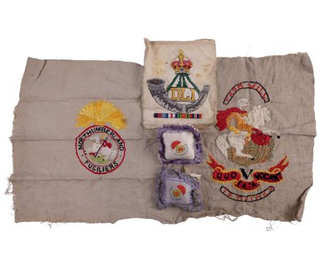 A group of Northumberland Fusiliers and Durham Light Infantry embroidered textiles including two small pincushions, Great War