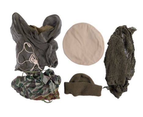 A US army camouflaged face veil together with a mosquito net, one other veil, a summer cap cover and a knitted woolen cap