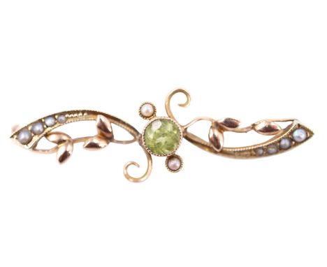 A Belle Epoque peridot and seed pearl brooch, having a 4.5 mm brilliant bezel-set between adorsed seed pearl accentuated flor