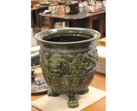 Large 19th century Art Pottery Green Jardiniere with lion mask handles raised on claw feet (a/f)