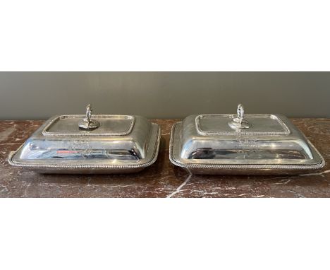 A pair of George III plain oblong entrée dishes and covers. Each with gardooned borders and detachable foliage ring handle, e