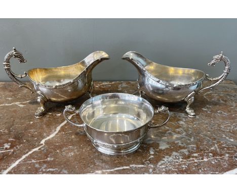 A three piece silver set of two sauceboats (x, y) and a loving cup (z). Sauceboats in 'Celtic' style with flying-scroll handl
