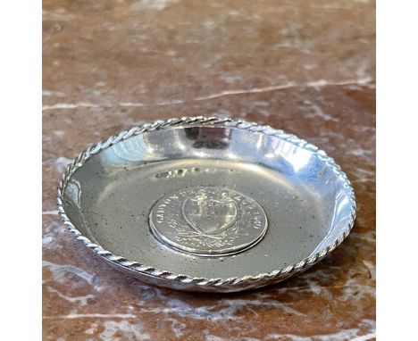 Two 20th century continental sterling silver commemorative coin dishes with braided rims. [a] Dish with coin commemorating Ca