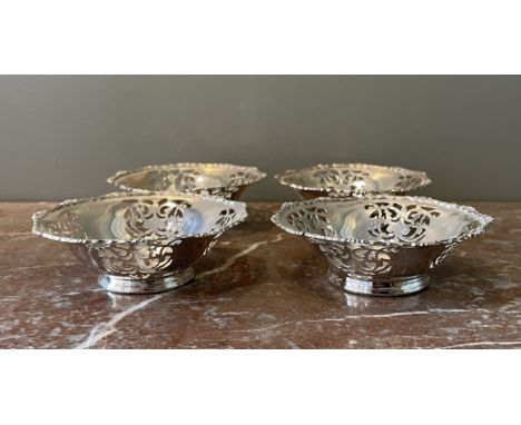 A set of four circular silver sweetmeat-dishes, each on moulded foot, the sides pierced with scrolls with anthemion and scrol