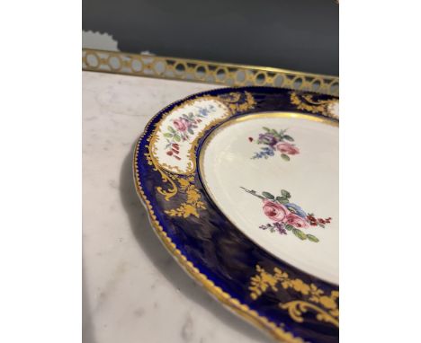 An 18th Century Sevres Porcelain Plate with an indented 'Sevres blue' rim, gold gilding and floral motifs. Sevres interlaced 