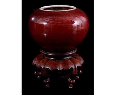 Porcelain sang de boeuf ball vase, China 20th century, 9 cm high, 13 cm diameter, on wooden console of 7.5 cm high