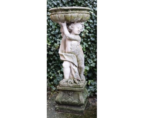 Composite garden sculpture bird drinking trough, carried by a putto, 89 cm high, bowl 47 cm in diameter, detached on a 30 cm 