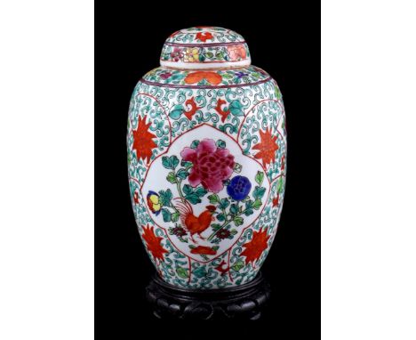 Porcelain lidded vase with polychrome floral decor with roosters, in cartouches, China 20th century, 21 cm high, on a wooden 