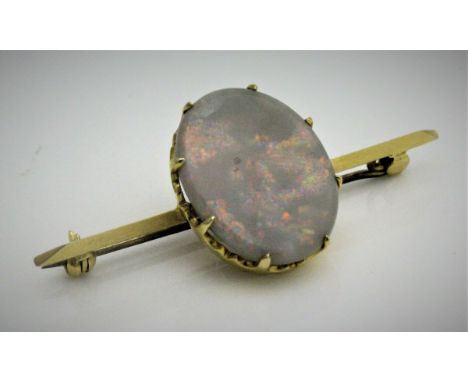 An opal set bar brooch, the opal of oval form with gold coloured mount, un-marked, stone approx 2 cm x 1.5 cm, 5.1 g