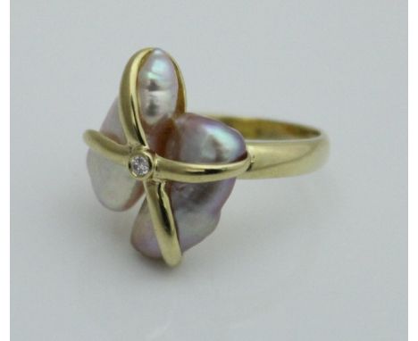 An 18ct gold ladies dress ring set with two blister pearls in an abstract setting with central solitaire diamond, overall wei