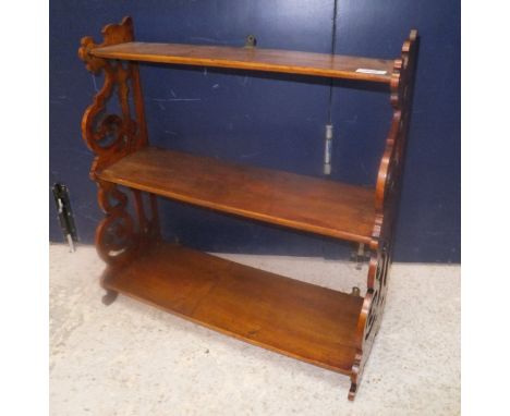 A circa 1900 mahogany three tier waterfall shelf unit on fretwork carved supports