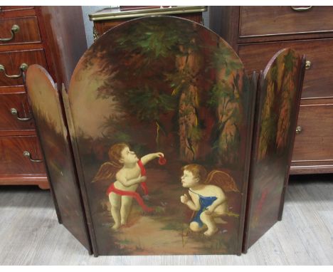 A three fold hand painted fire screen with scenes of putti in woodland, 75cm tall  