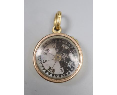 An 18ct cased pendant compass, with bale, 22mm, gross 14 grams.CONDITION: Bale only stamped 18ct. Some wear to the engine tur