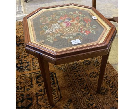 An grois point tapestry panel, inset in the top of a hexagonal mahogany table, width 54cm, depth 48cm, height 48cm