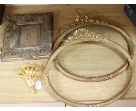 A pair of Victorian ornate gilt gesso oval picture frames, 50 x 55cm, a similar wall shelf and a picture