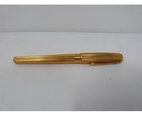 A gold plated Dupont fountain pen with two colour 18k nib. Engine turned decoration to the pen. Length 14cm.