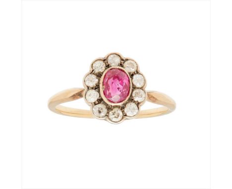 A ruby and diamond set cluster ring millegrain set with an oval-cut ruby in a border of eight-cut and old round-cut diamonds,