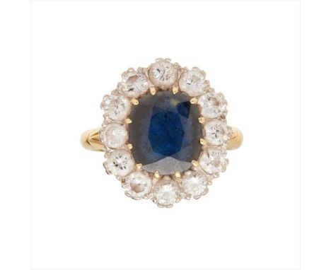 An 18ct sapphire and diamond set cluster ring claw set with a cushion-cut sapphire, in a border of round brilliant-cut diamon