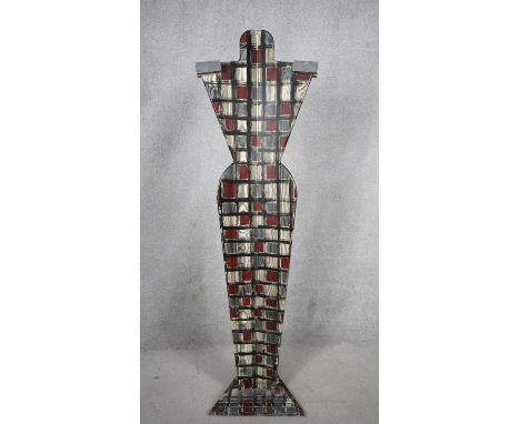 A mid-century painted wooden clothes mannequin, sitting on a triangular base and decorated with an abstract colourful design.