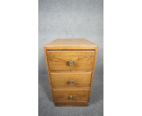 A mid century light oak three drawer pedestal chest on plinth base. H.63 W.35 D.46 