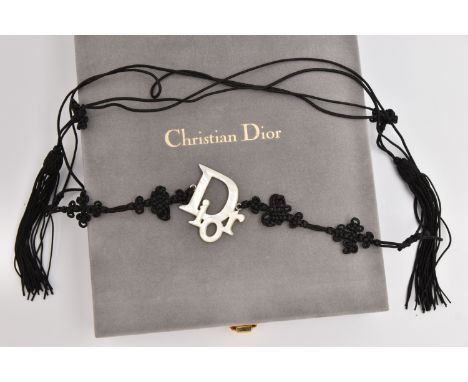 A CHRISTIAN DIOR BELT, a black cordette belt with oriental detail and tassel terminations, fitted with a central mother of pe