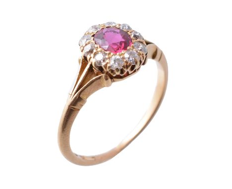 An early 20th century 18 carat gold ruby and diamond cluster ring, circa 1900, the central oval cut ruby within a surround of