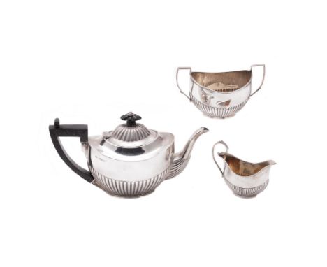 An Edwardian silver oval half gadrooned tea pot and sugar basin by Robert Pringle & Sons, London 1906, the teapot with a comp