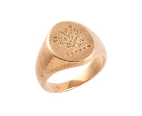 A gold coloured signet ring by Garrard, the oval panel seal engraved with a family crest of a  tree, signed Garrard, finger s