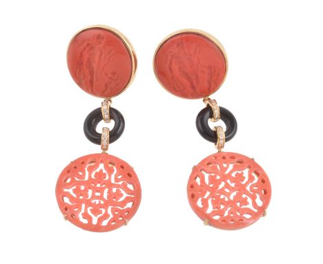 Y A pair of coral, onyx, diamond and glass pendent earrings, the carved and pierced coral disc drops suspended by onyx discs 