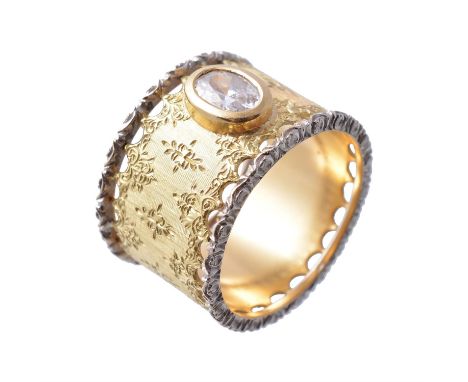 A gold coloured ring by Mario Buccellati, the foliate engraved and pierced band set with an oval shaped cubic zirconia, signe