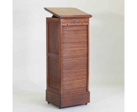 An early 20th century light oak architect's filing cabinet, with a lift-up top and tambour front, stamped to the lock plate K