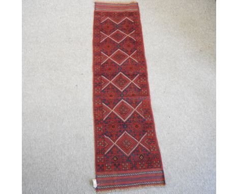 A woollen runner, with five central medallions, on a red ground, 237 x 60cm