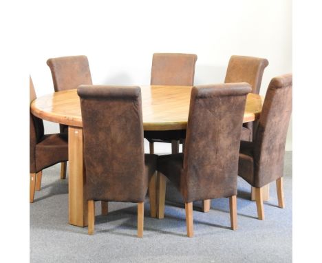 A modern light oak circular dining table, 192cm diameter, together with seven upholstered high back dining chairs