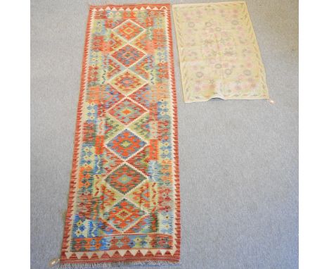 A kelim runner, with seven central medallions, on an orange ground, 250 x 82cm, together with a floral embroidery, 121 x 74cm