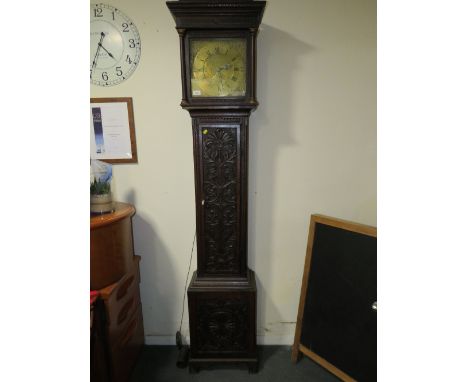 THOMAS WOODRUFF OF SALOP - A BRASS FACED CARVED OAK LONGCASE CLOCK, the face with date aperture and 30 hour movement, housed 