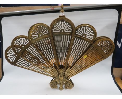 A vintage brass peacock firescreen 