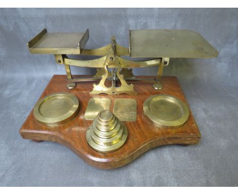 A VINTAGE SET OF POST OFFICE BRASS SCALES, on a wooden base, together with a set of brass weights, L 37 cm, H 20 cm