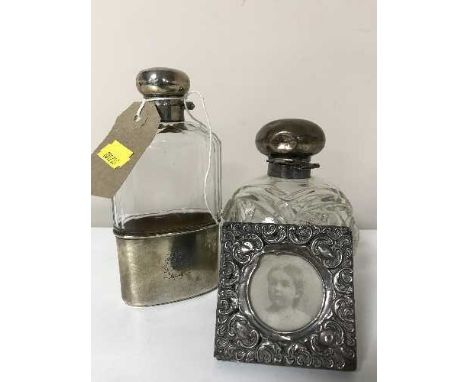 A silver lidded scent bottle together with a silver and glass hip flask and a silver embossed photo frame