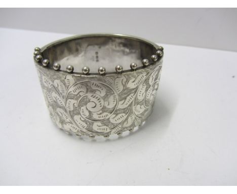 SILVER BANGLE, large hinged silver bangle with foliate engraved decoration 34 grams