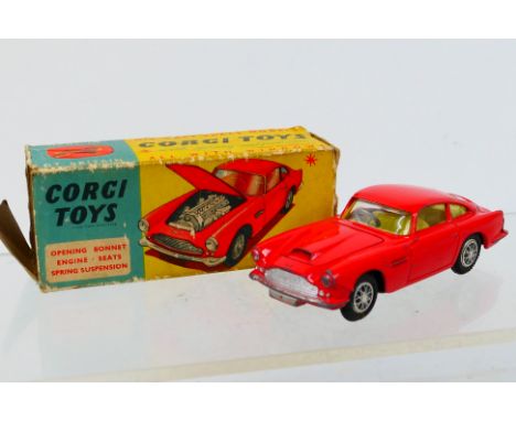 Corgi Toys - A boxed Corgi Toys #218 Aston Martin DB4. The model in red with lemon interior and spun hubs, has some age wear 