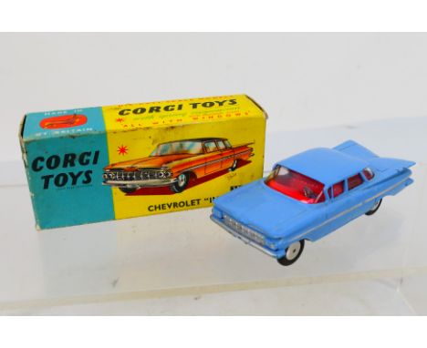 Corgi Toys - A boxed Corgi Toys #220 Chevrolet Impala. The model in light blue with red interior and spun hubs  has a couple 